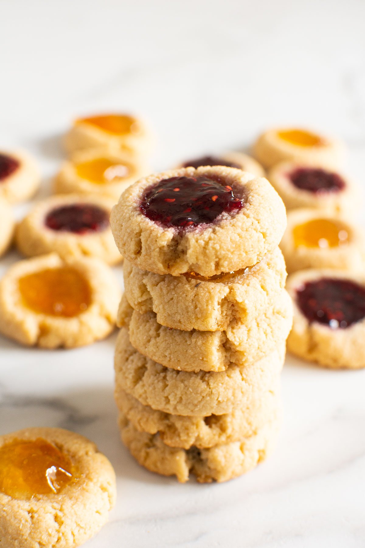 Raspberry thumbprint cookies stacked on top of each other.