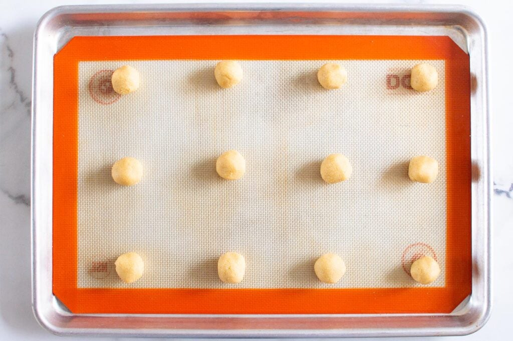 gluten free thumbprint cookies rolled into balls on baking sheet