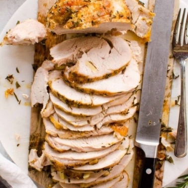 boneless turkey breast roast on a platter with knife