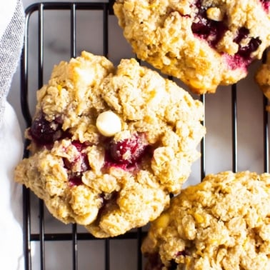 Healthy oatmeal cranberry cookies with white chocolate chips on a cooling rack.