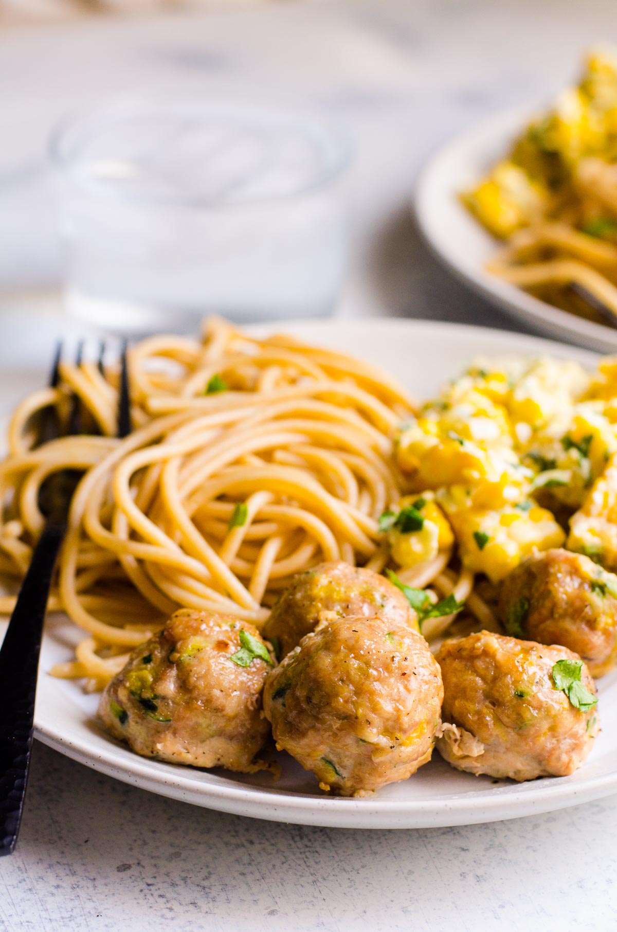 turkey balls with spaghetti noodles and corn on a plate for serving healthy dinner