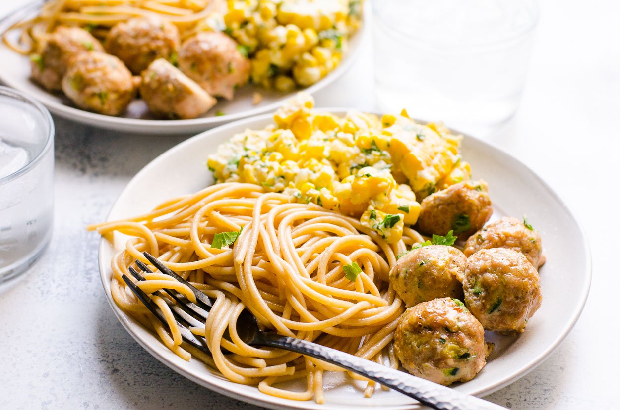 baked turkey meatballs on plate for serving with noodles and corn