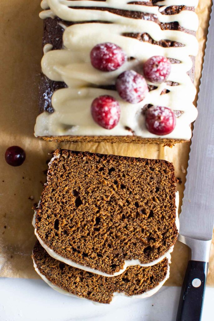 sliced gingerbread loaf cake sliced with icing and cranberries