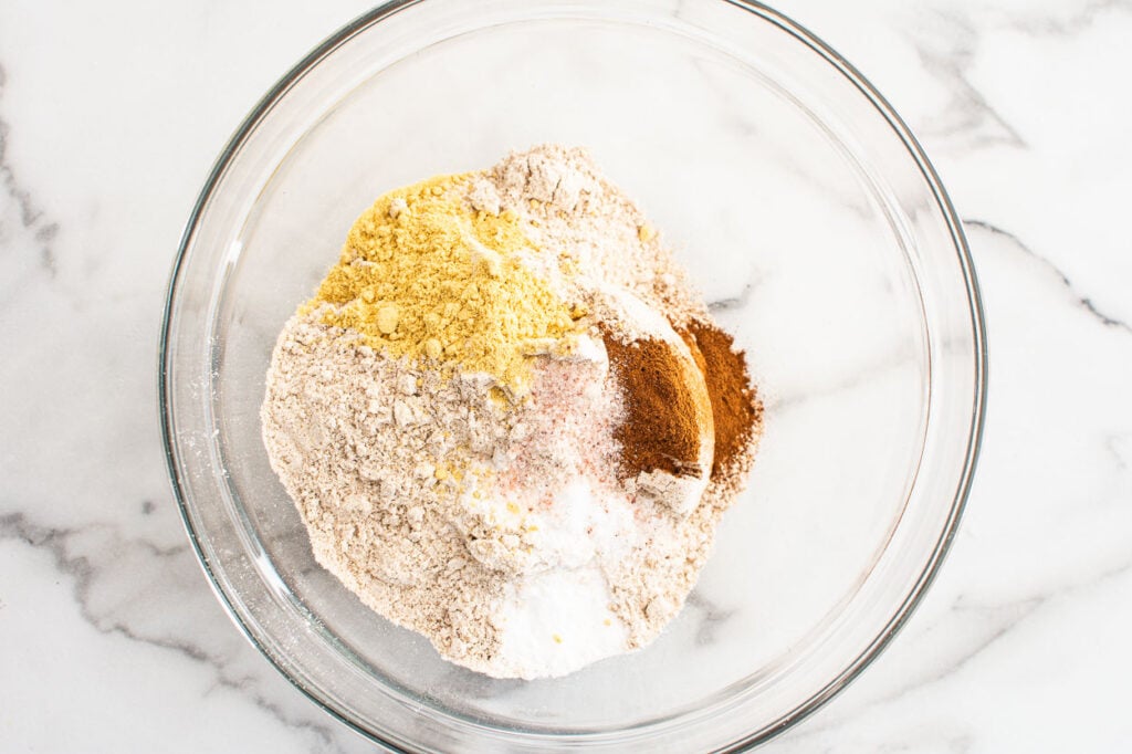 Whole wheat flour, cinnamon, ginger and baking ingredients in bowl.