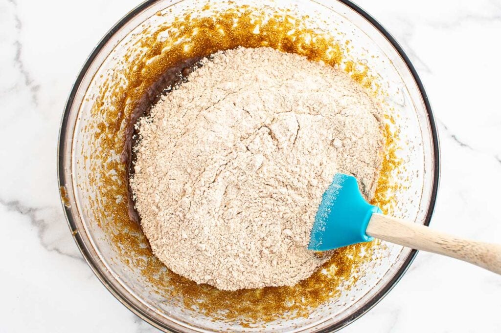 Adding dry ingredients to bowl of wet ingredients. 