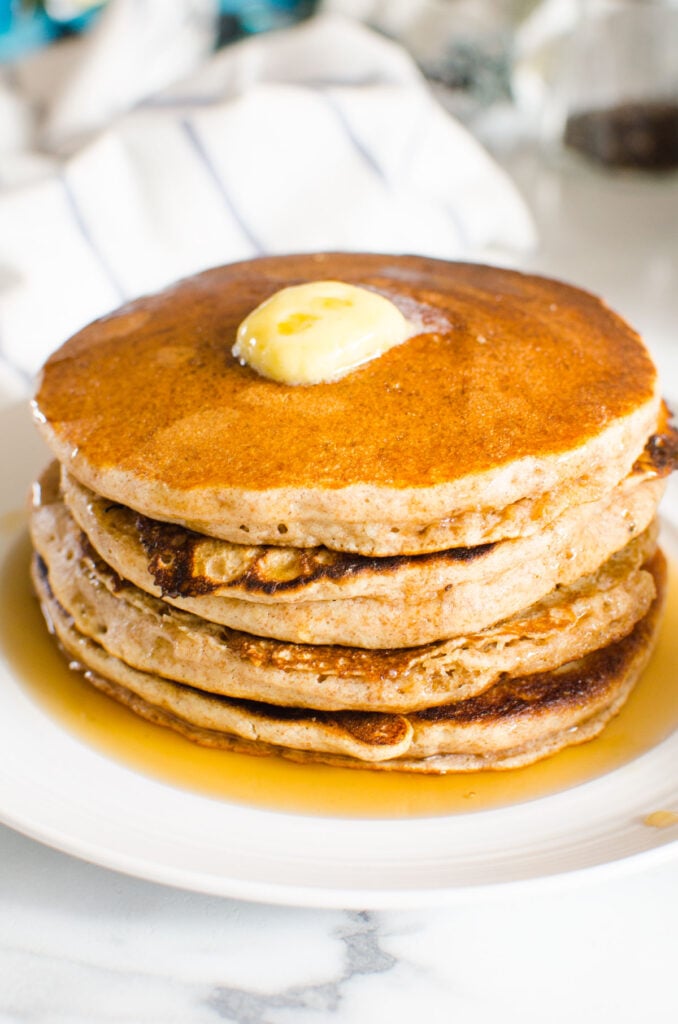 a stack of healthy pancakes with butter and maple syrup on a plate