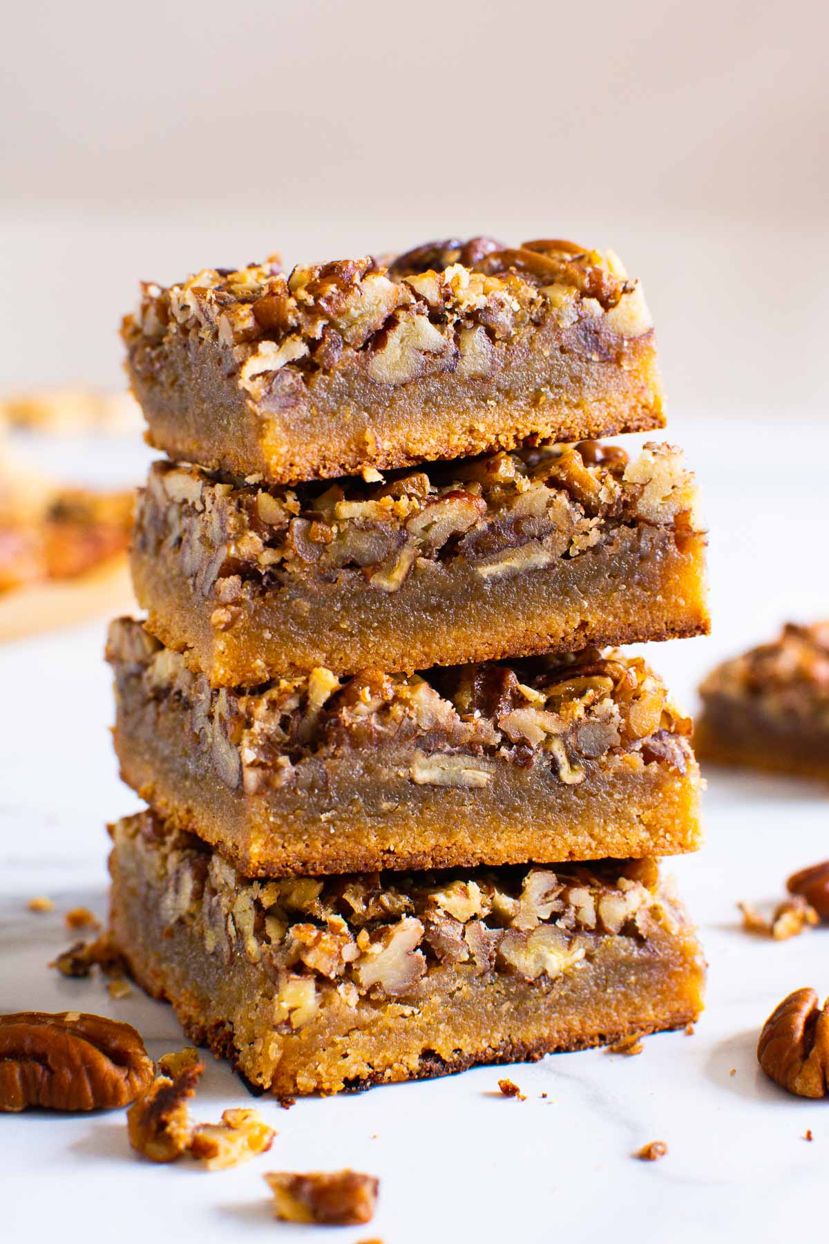 Four healthy pecan pie bars stacked.