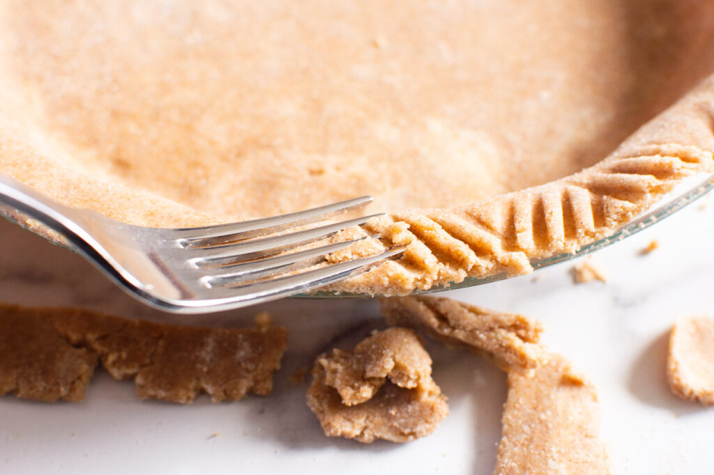 making nice edge with a fork on healthy pumpkin pie crust