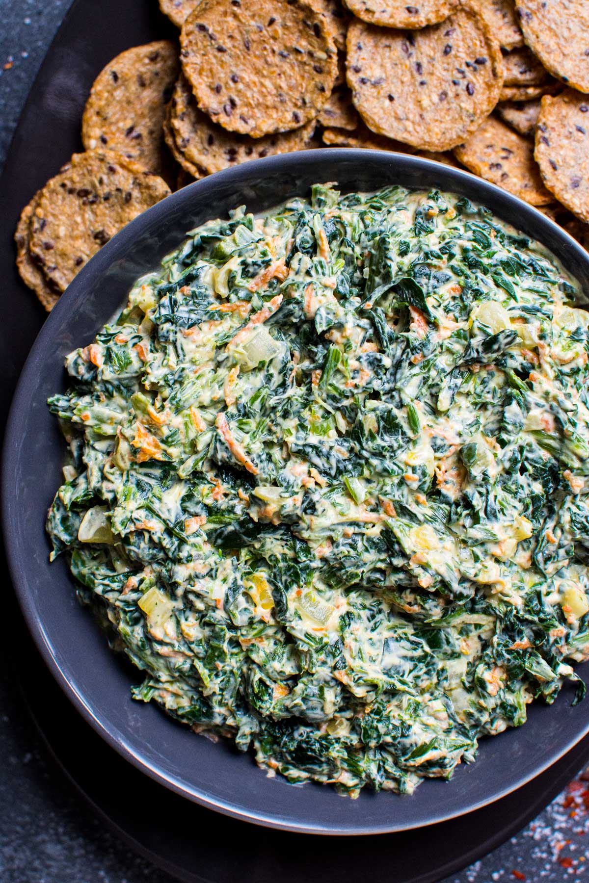 cold spinach dip recipe in. bowl with crackers
