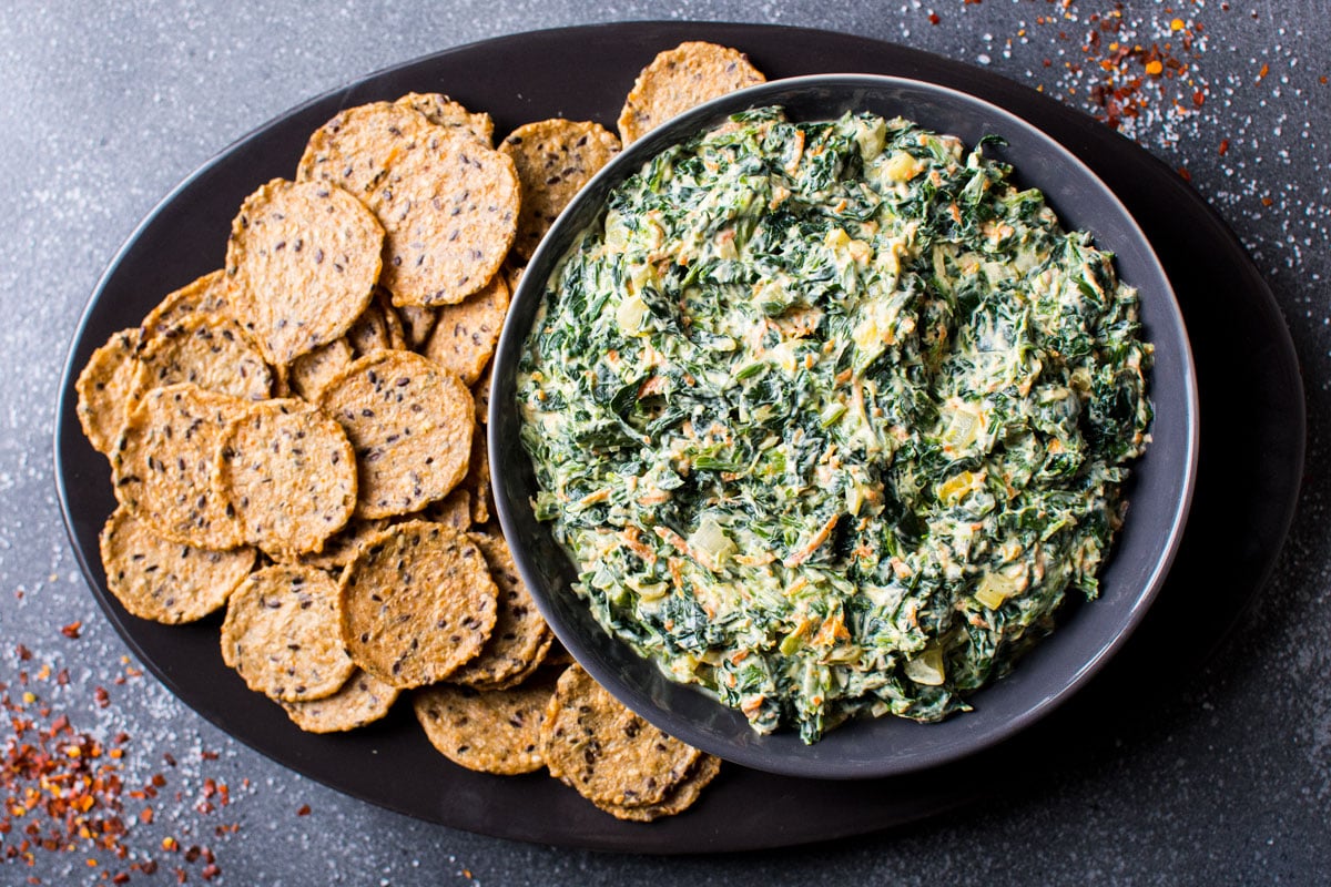 cold spinach dip ready to eat on platter with crackers
