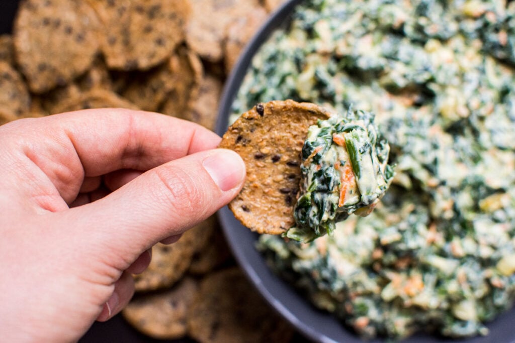 homemade spinach dip served on a whole grain cracker