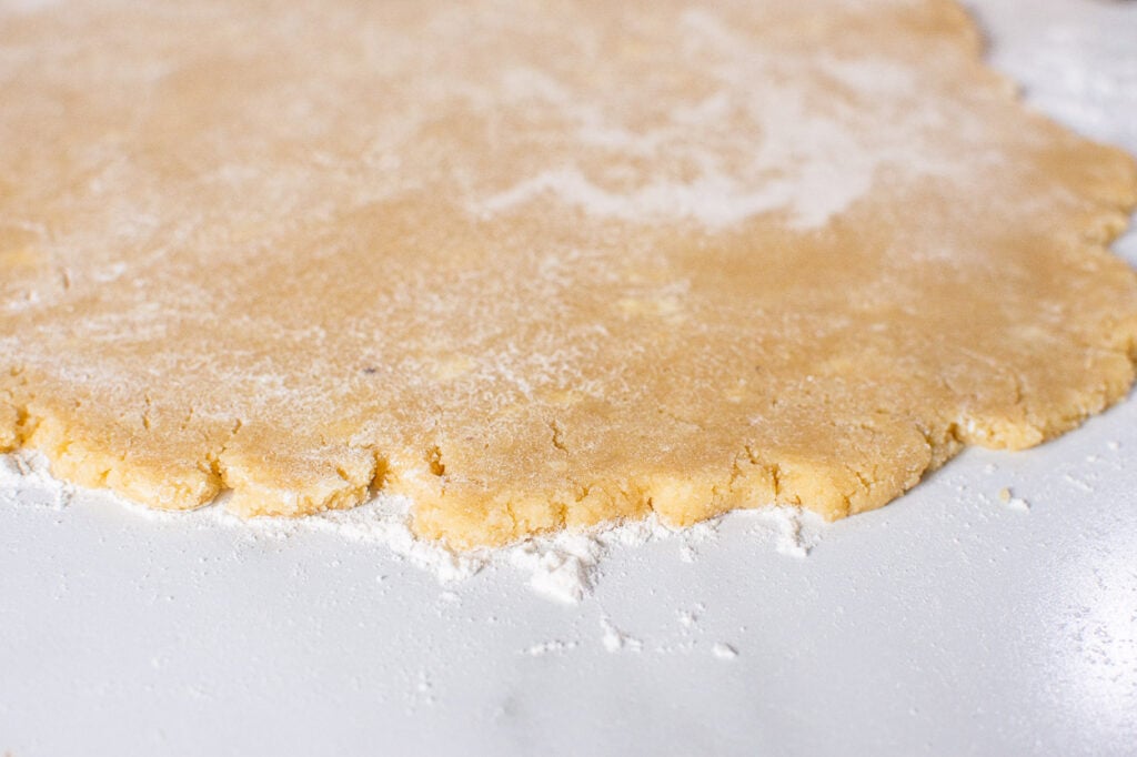 Rolled out sugar cookie dough on floured surface.