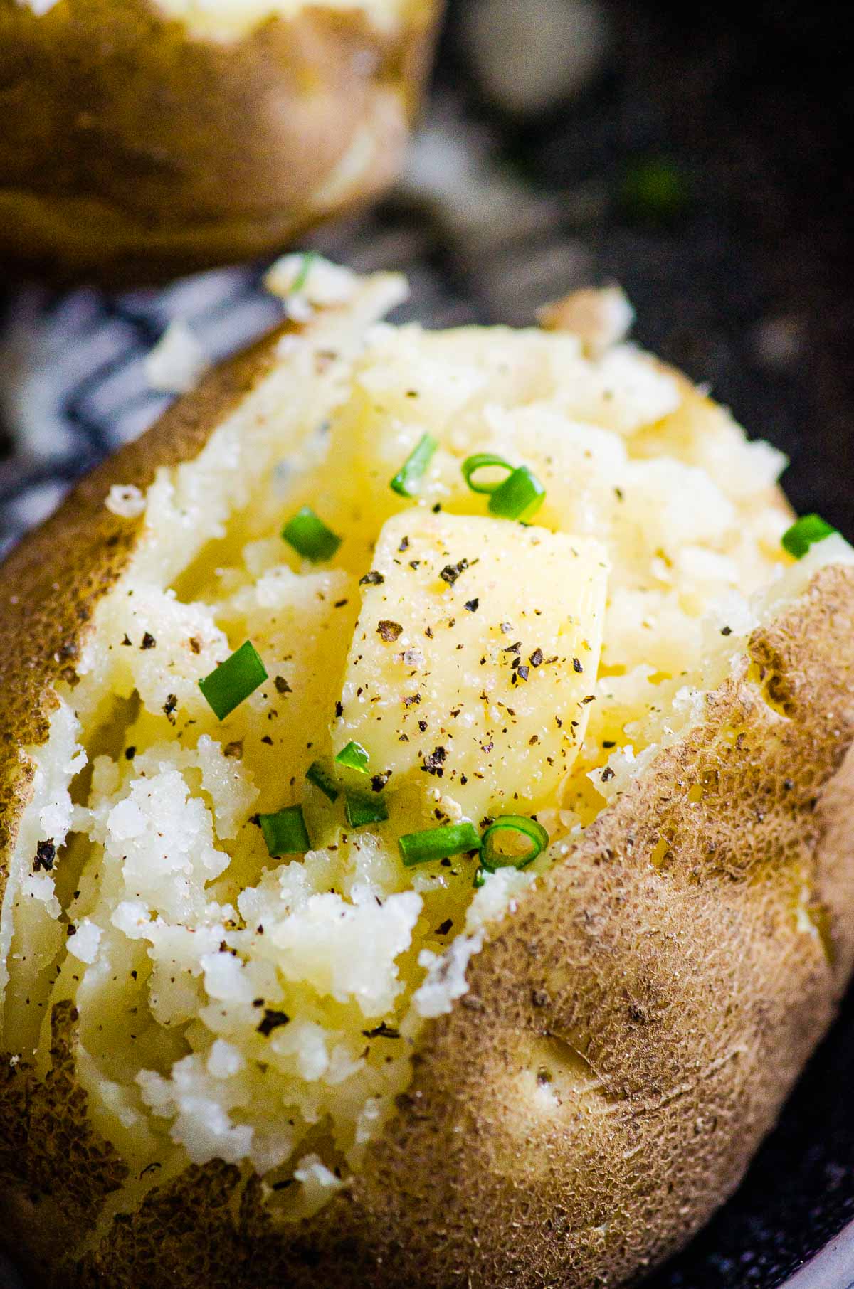 Close up of Instant Pot baked potatoes with butter and chives.