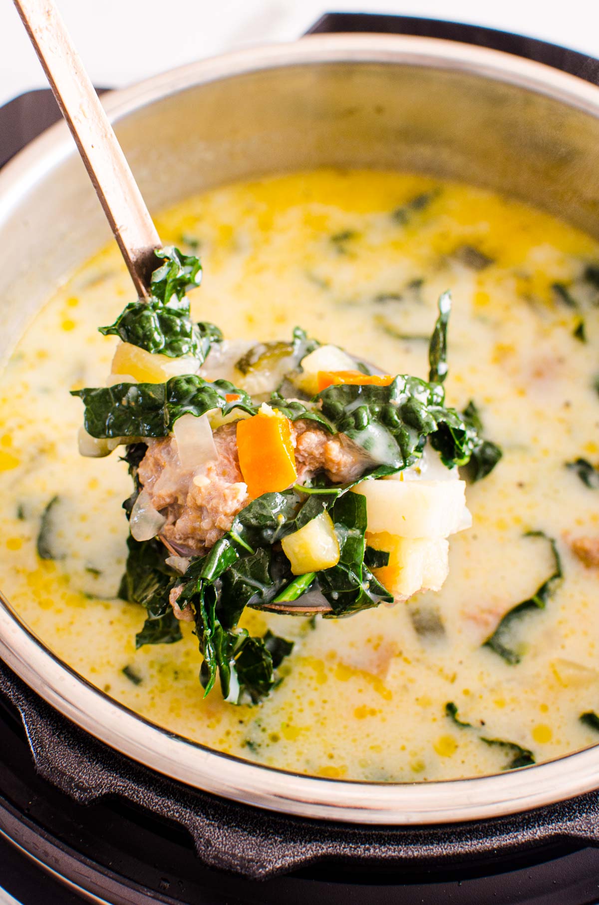 olive garden tuscan soup in instant pot being ladled showing kale potatoes and carrots