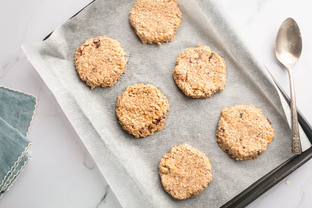 flattened healthy trail mix cookies on parchment lined pan