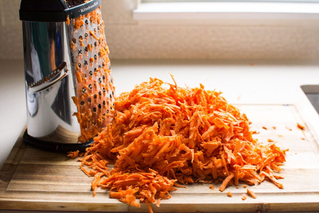 shredded sweet potatoes on cutting board and grater