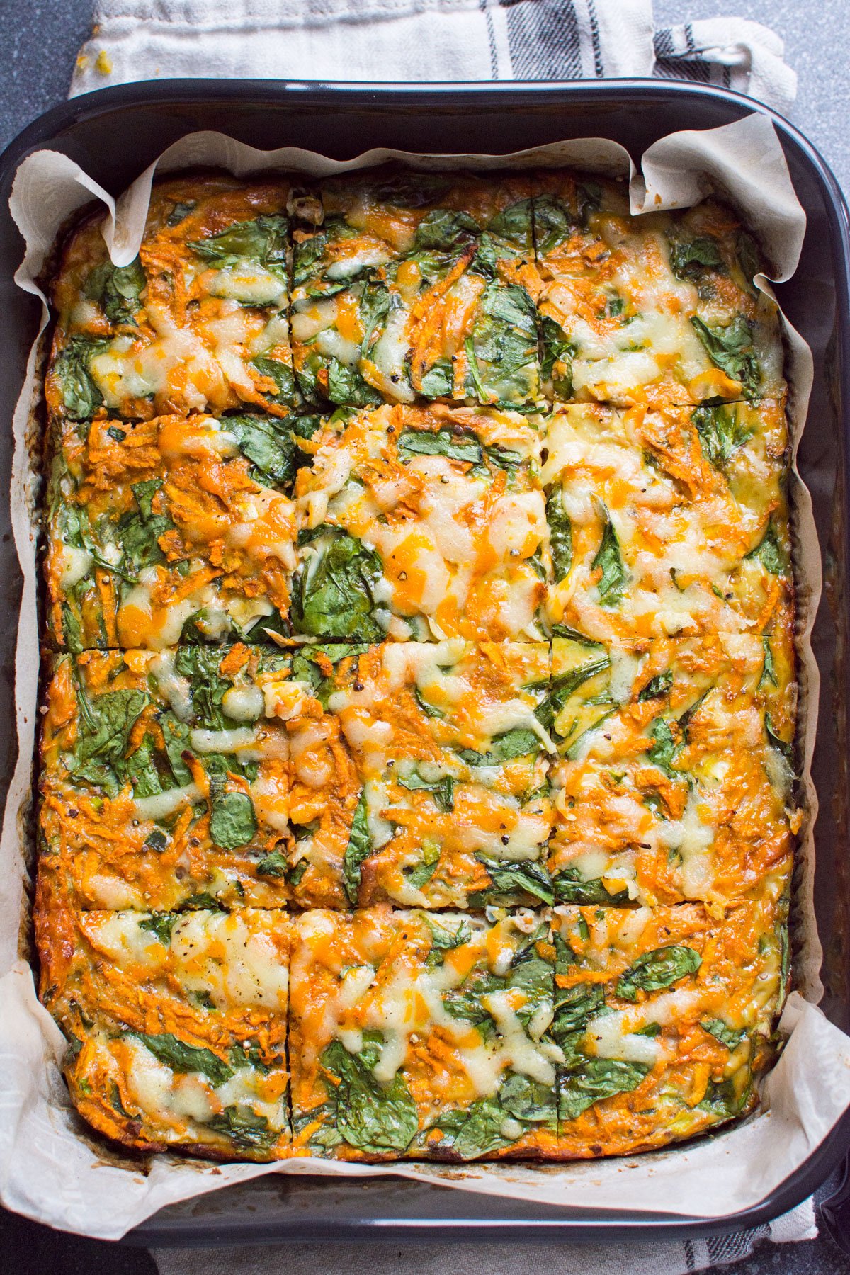 Sweet potato egg breakfast casserole with spinach in a baking dish.