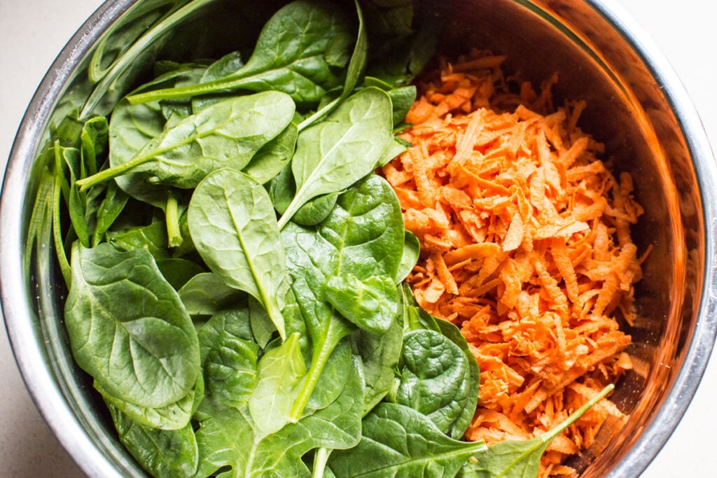 shredded yams and spinach in metal bowl