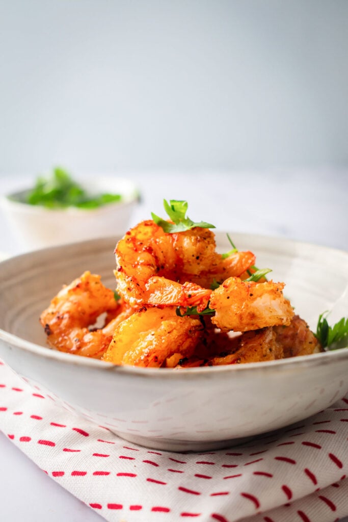 no breading air fryer shrimp in a bowl for serving with white towel with red dots