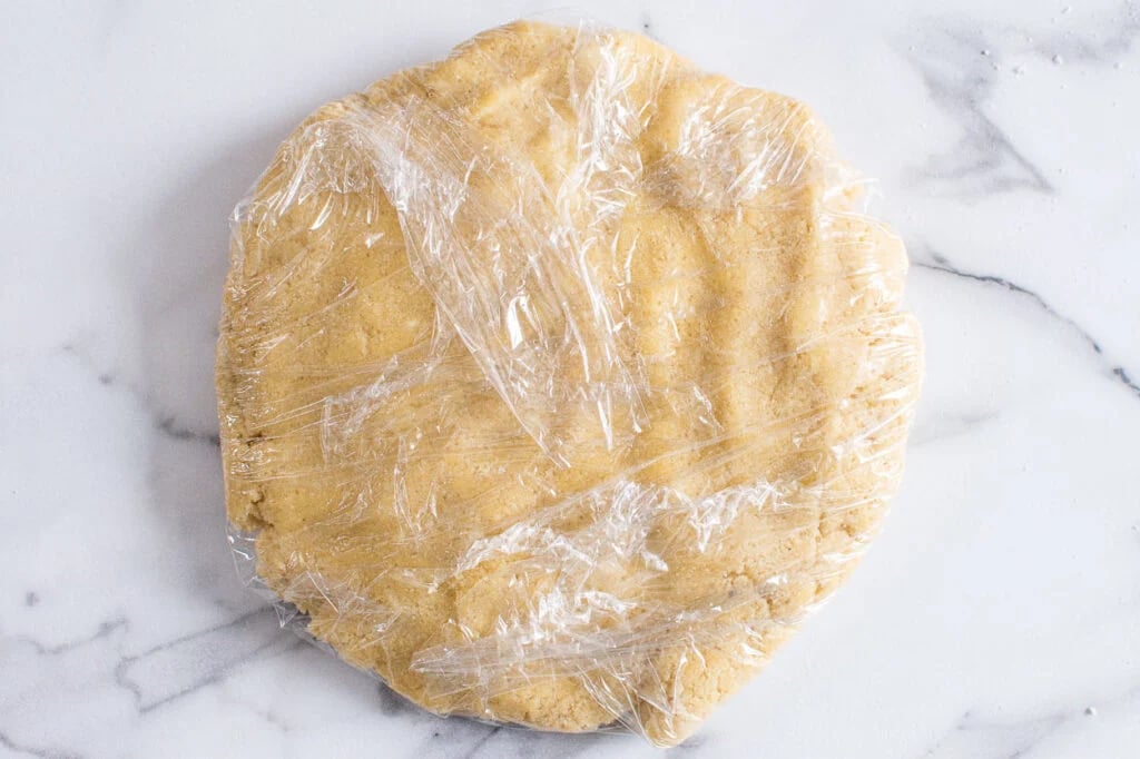 Shortbread dough wrapped in plastic wrap to chill.