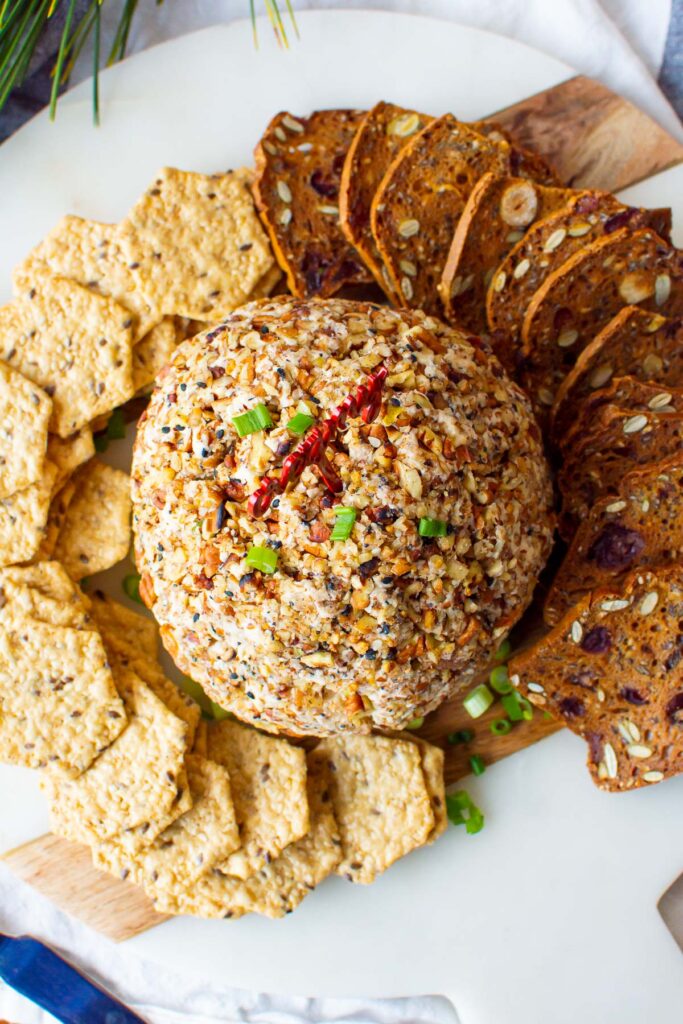 holiday cheese ball with cream cheese on a platter with crackers