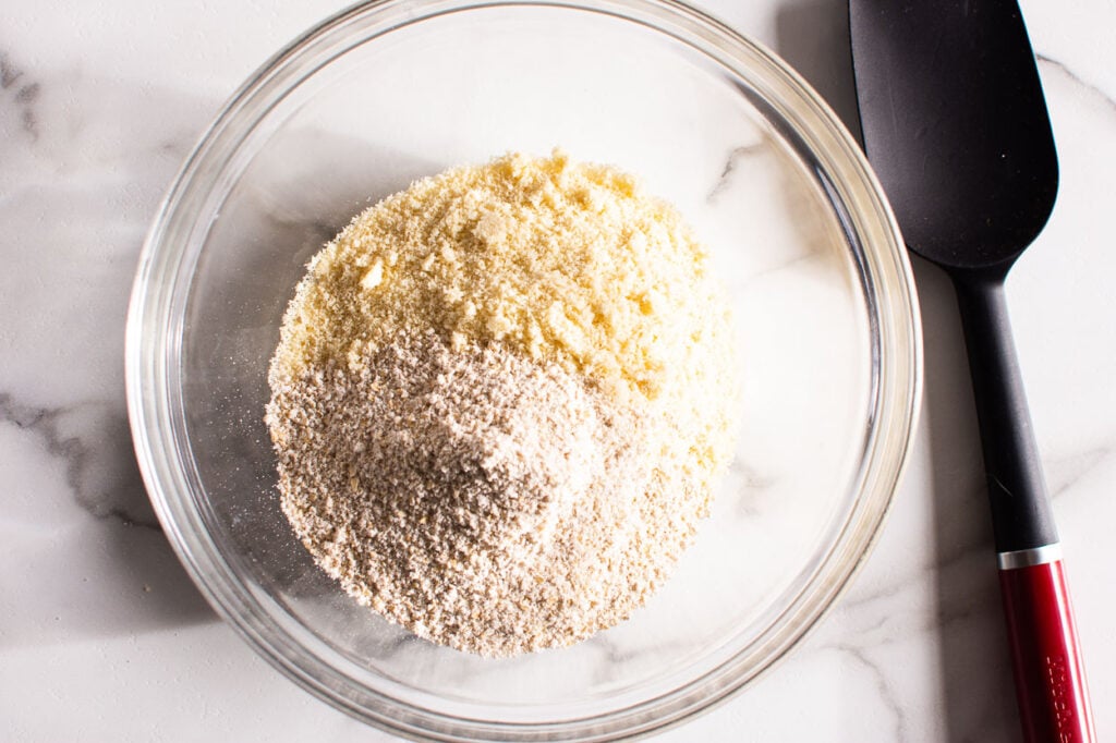 Mixing oat flour and almond flour together in a bowl.