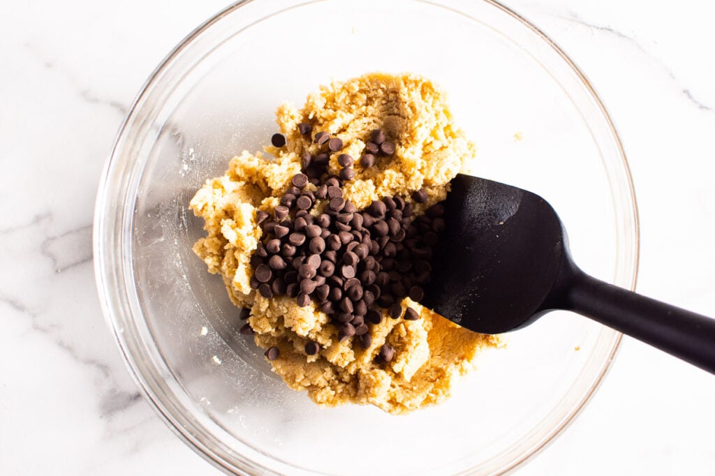 mixing chocolate chips into almond flour cookie dough
