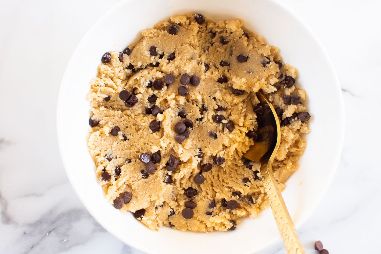 Edible cookie dough in a bowl with a spoon.