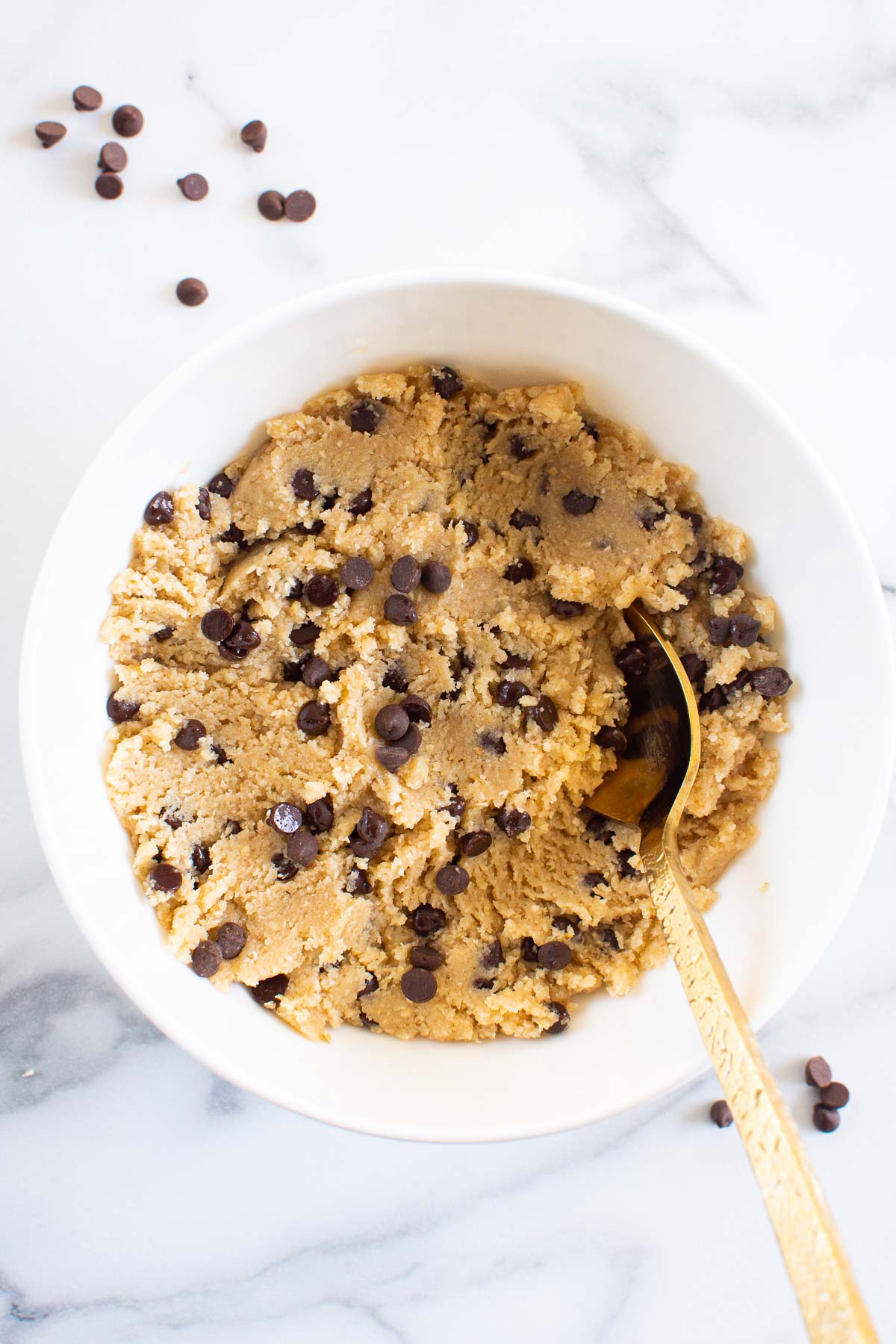 Healthy chocolate chip cookie dough in a bowl with spoon.