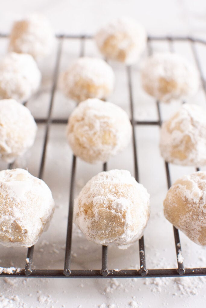 healthy snowball cookies with walnuts on baking rack cooling