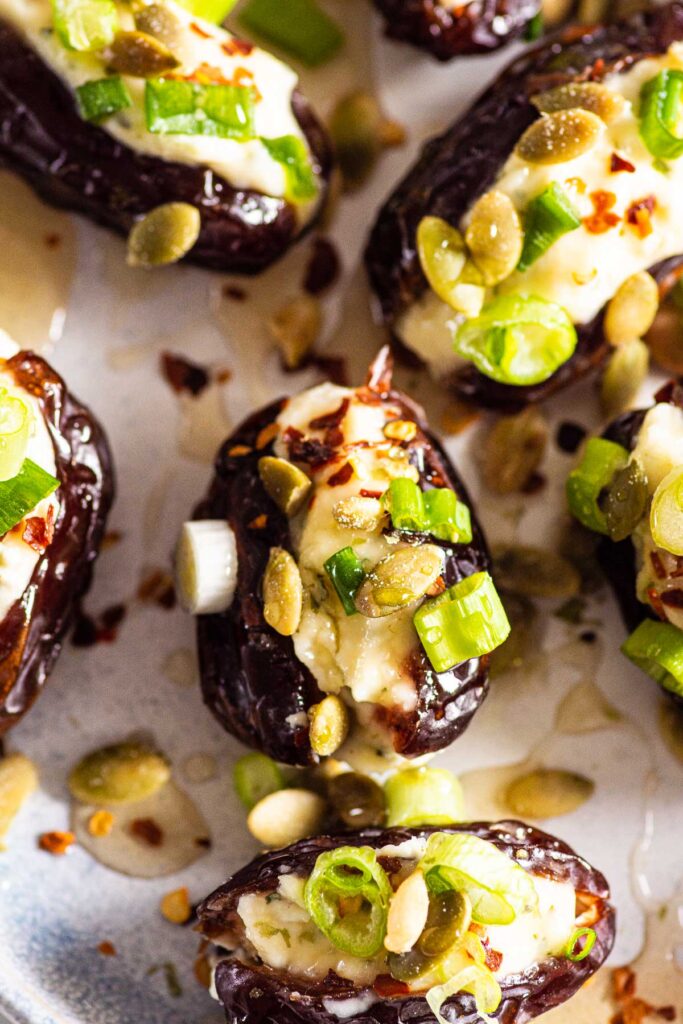 Close up of stuffed dates with green onion and pumpkin seeds.