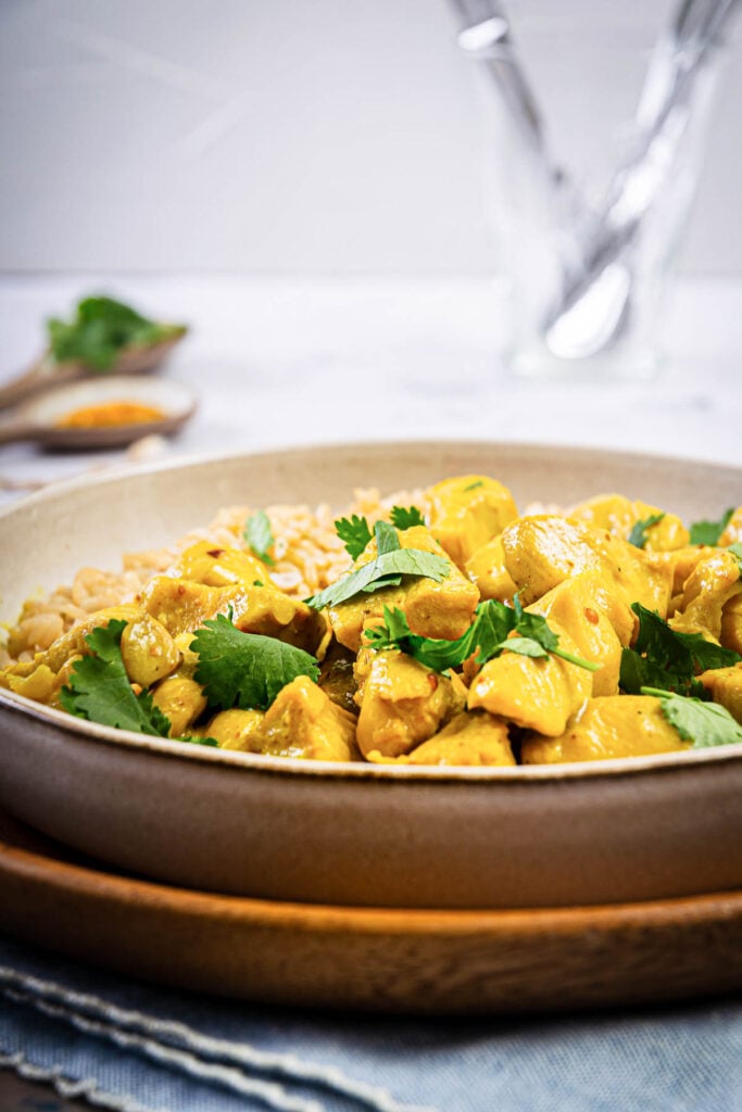 instant pot chicken curry being served in a bowl with rice and garnish 