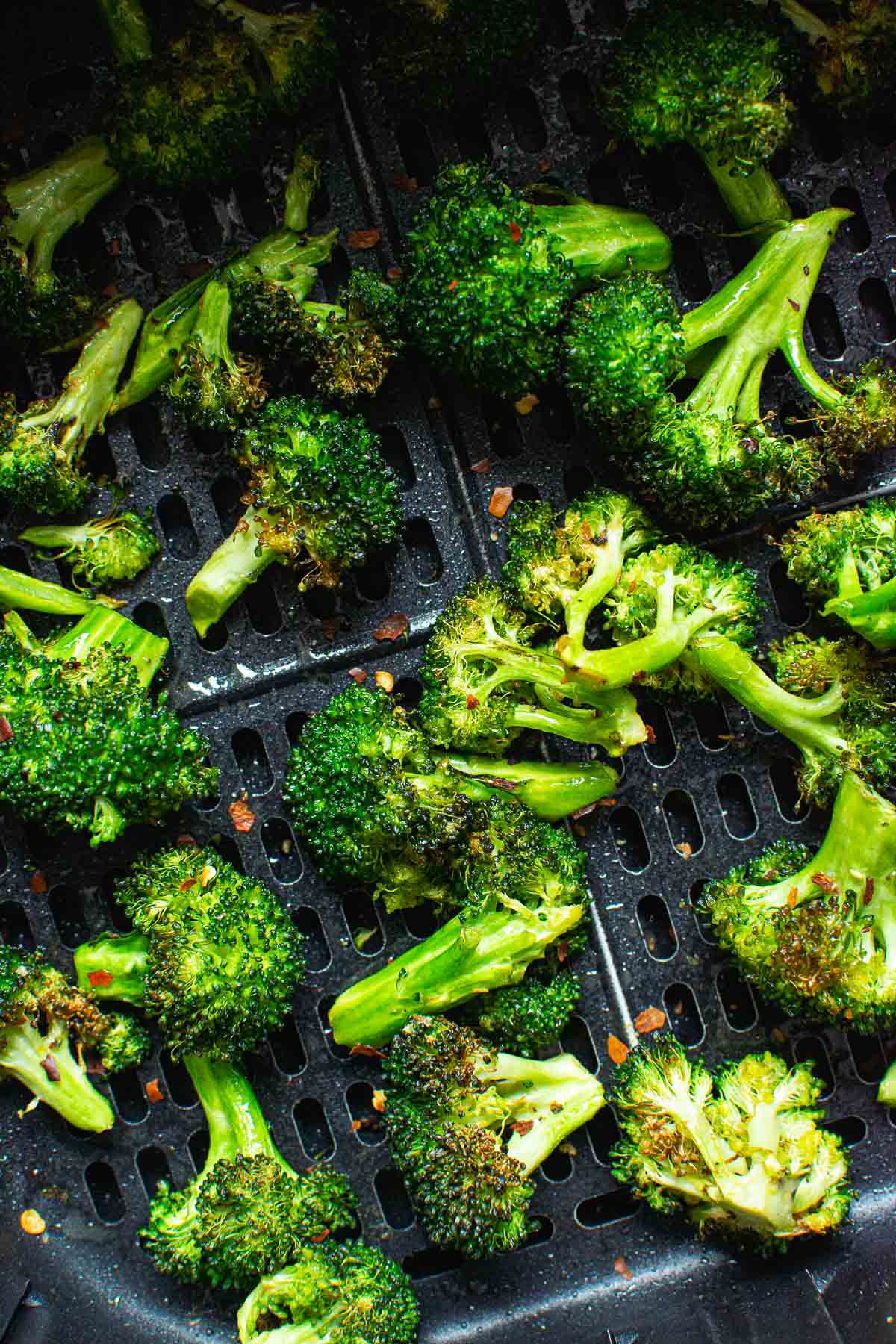 Air fryer broccoli garnished with red pepper flakes.