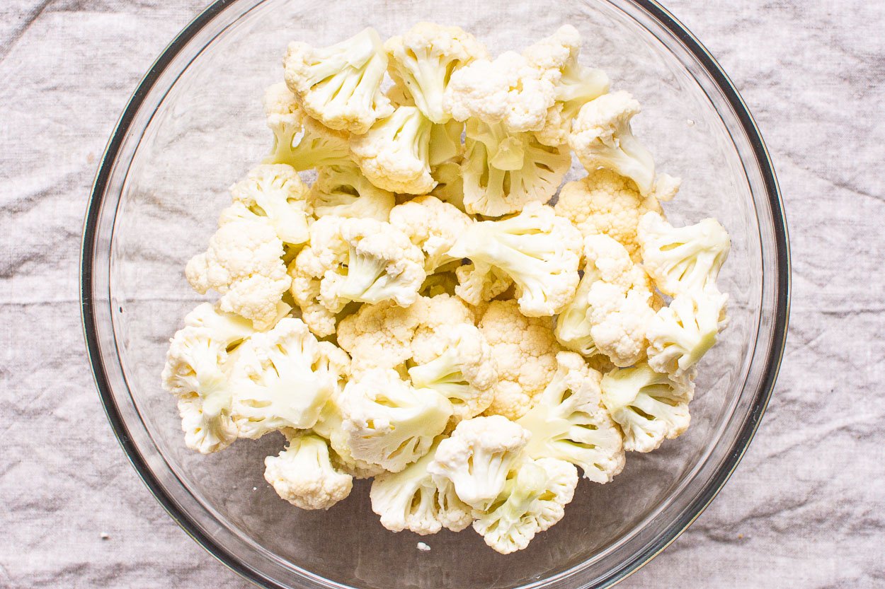 Cauliflower florets in glass bowl.