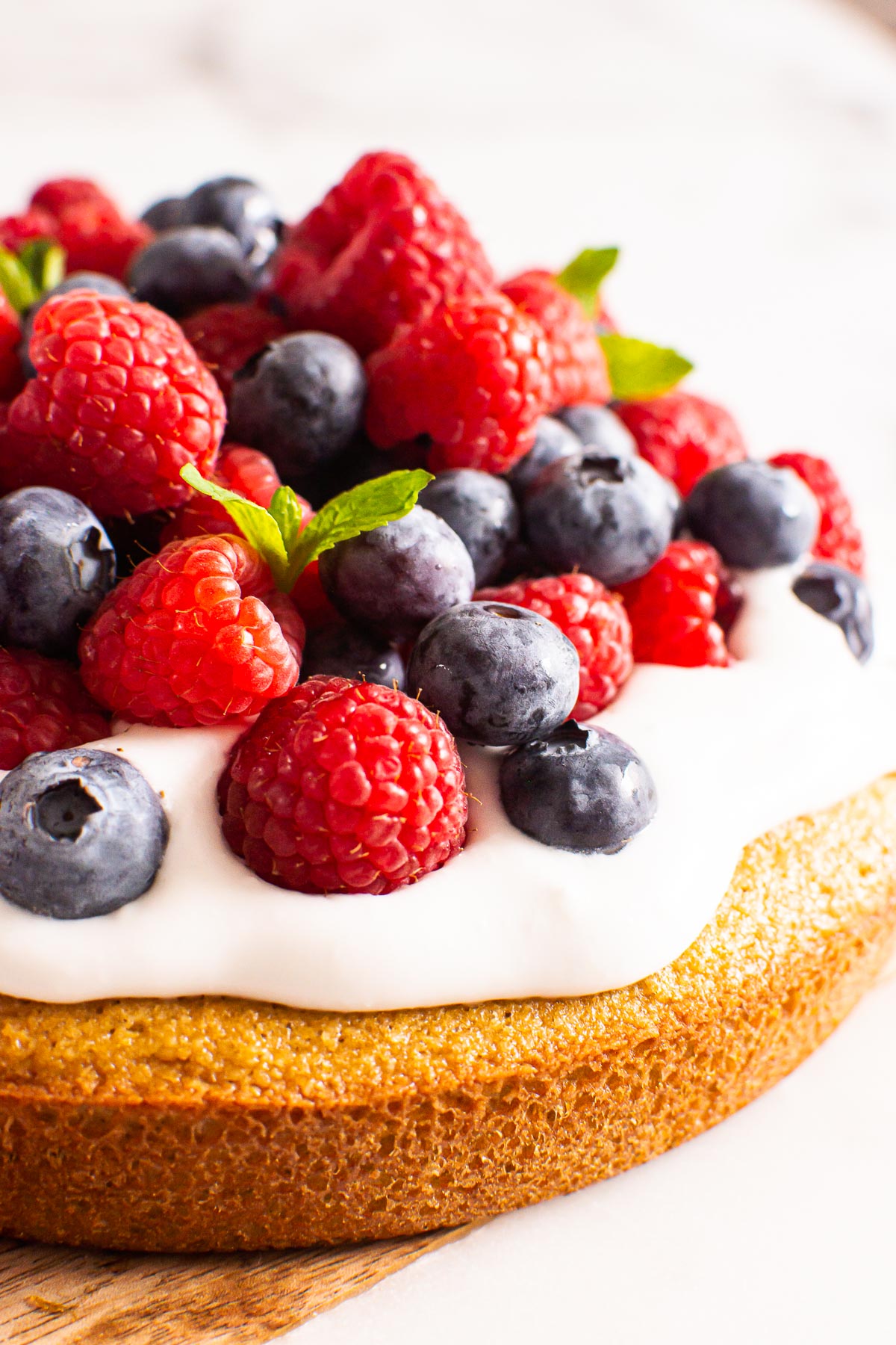 Almond flour cake topped with whipped cream, blueberries and raspberries.