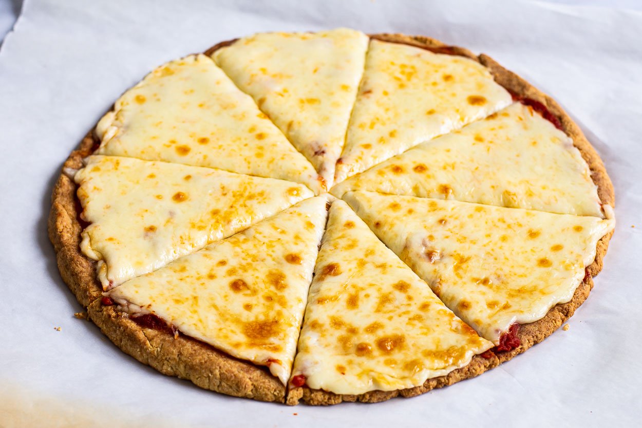 Cheese pizza cut into eight slices on parchment paper.