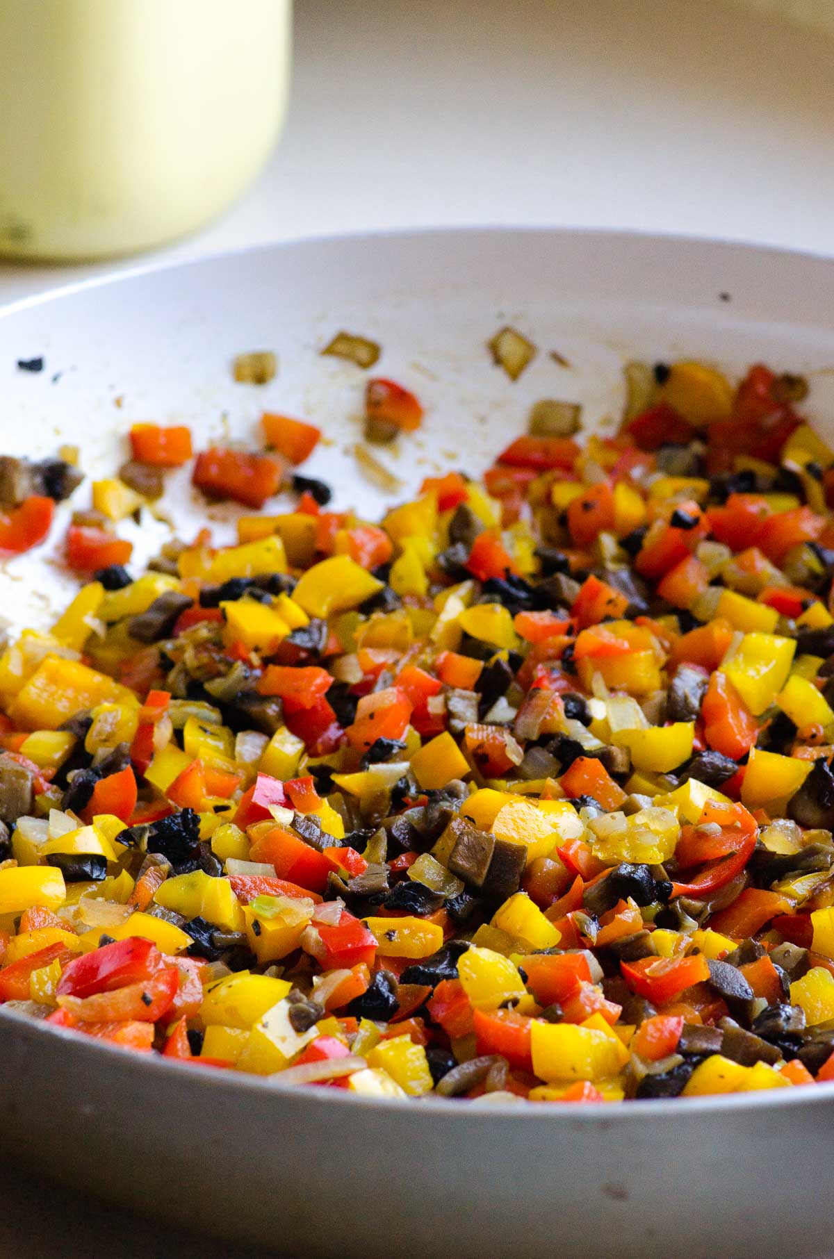 Chopped peppers, onion, and mushrooms in skillet.