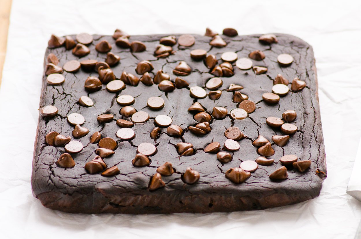 Uncut brownies cooling on parchment paper.