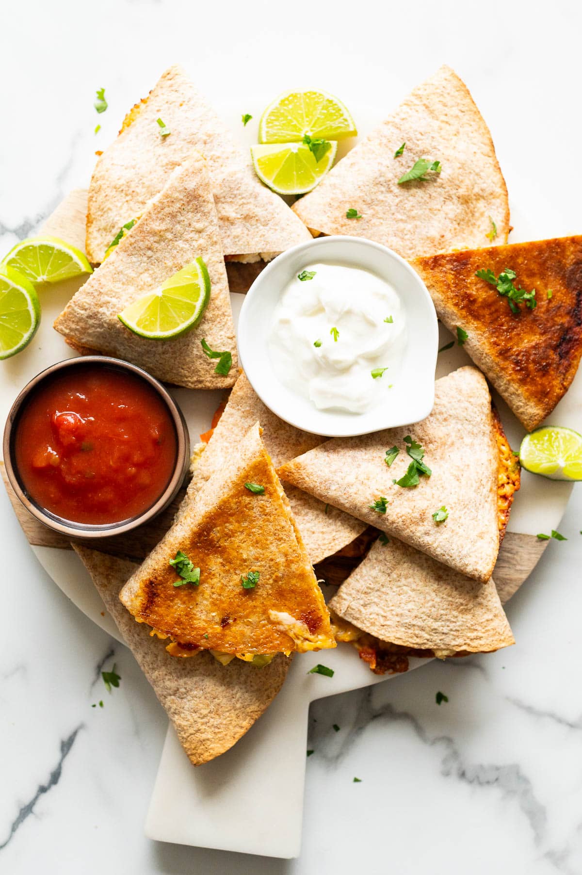 Chicken quesadillas with sour cream and salsa.