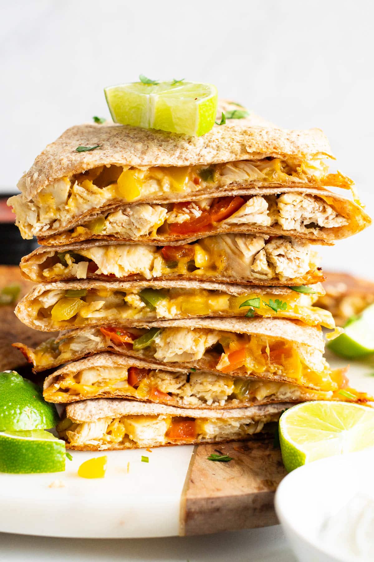 A stack of chicken quesadillas with lime on top.