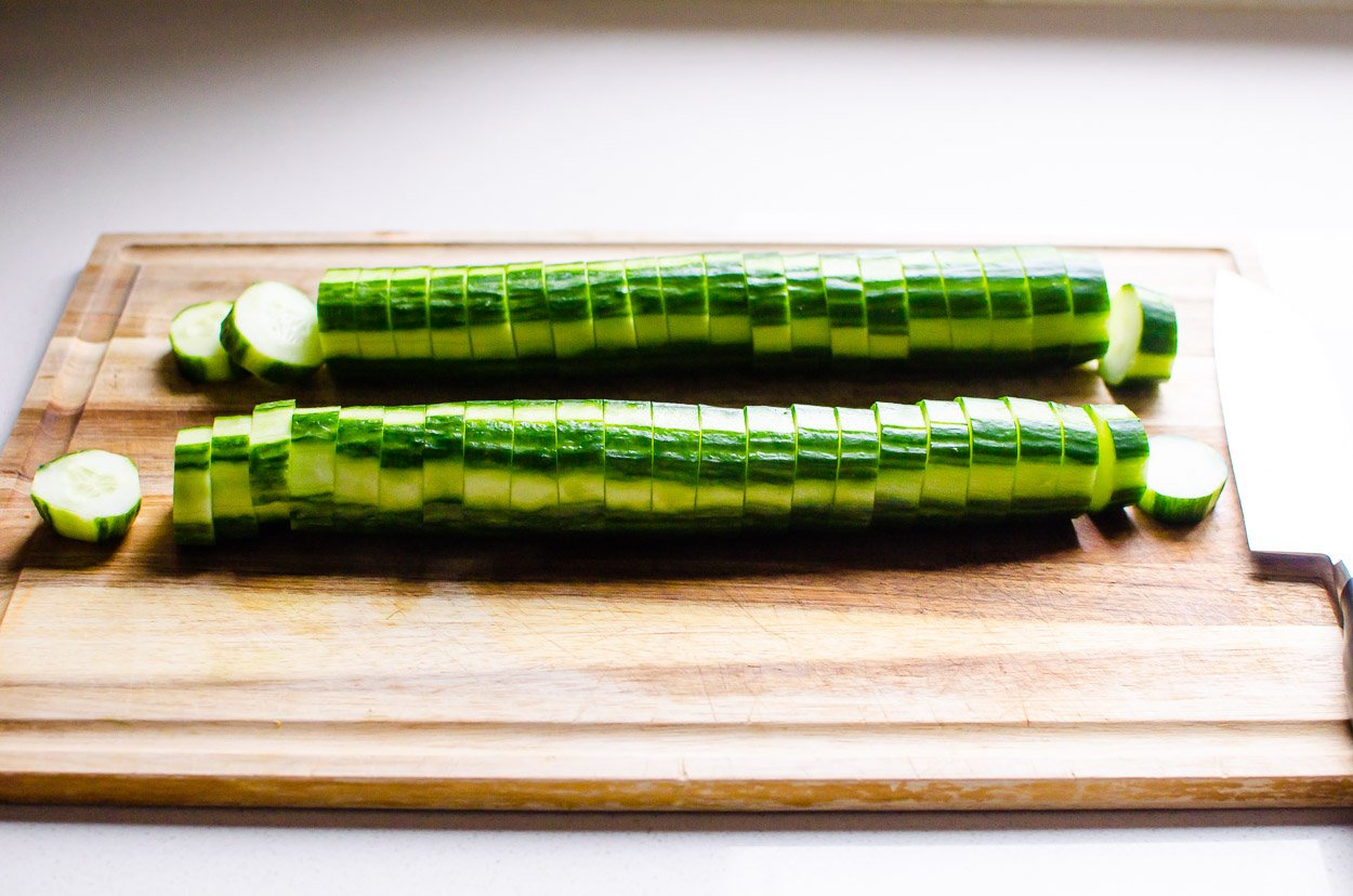 Cucumbers sliced on cutting board.