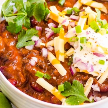 instant pot beef chili recipe topped with cilantro onion and cheese