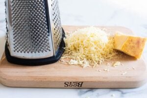 fresh grated parmesan cheese on cutting board