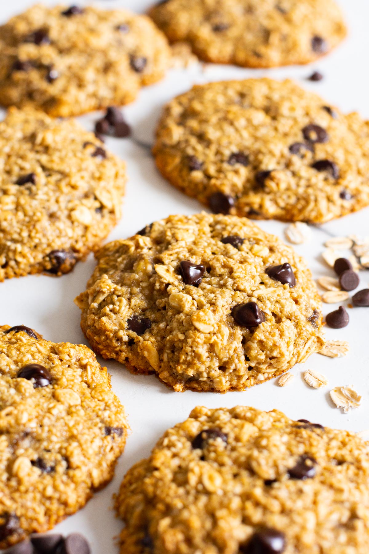 Healthy banana oatmeal cookies with chocolate chips and oats on counter.