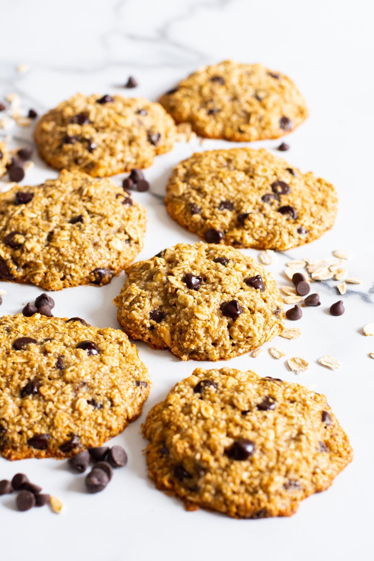 Healthy banana oatmeal cookies with chocolate chips and oats on a flat surface.