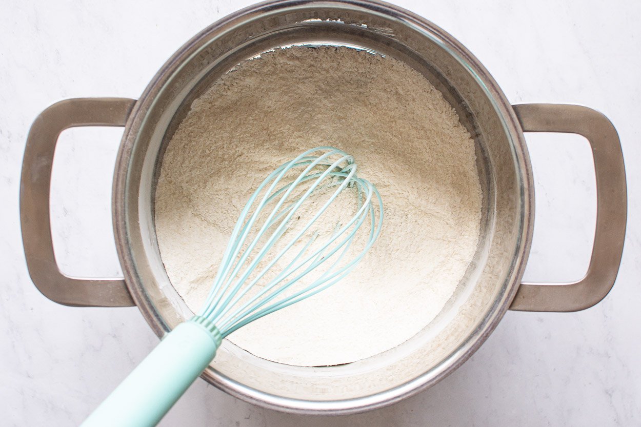 Whisked flour and sugar in a saucepan.