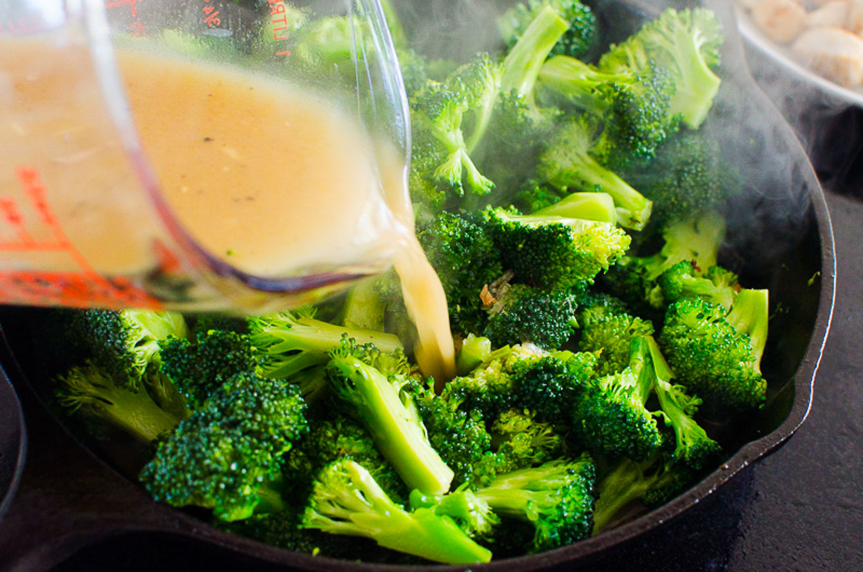 adding sauce to broccoli stir fry