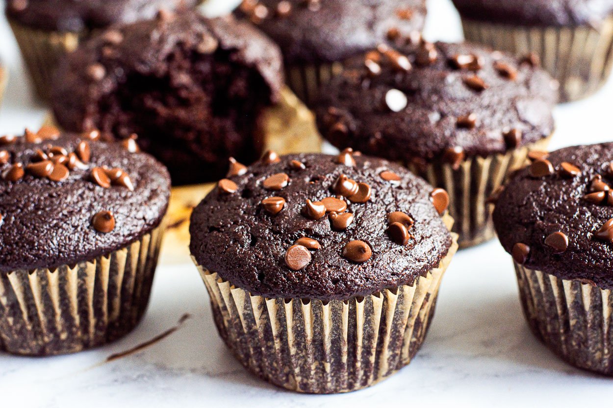 Healthy chocolate muffins with chocolate chips on a counter.