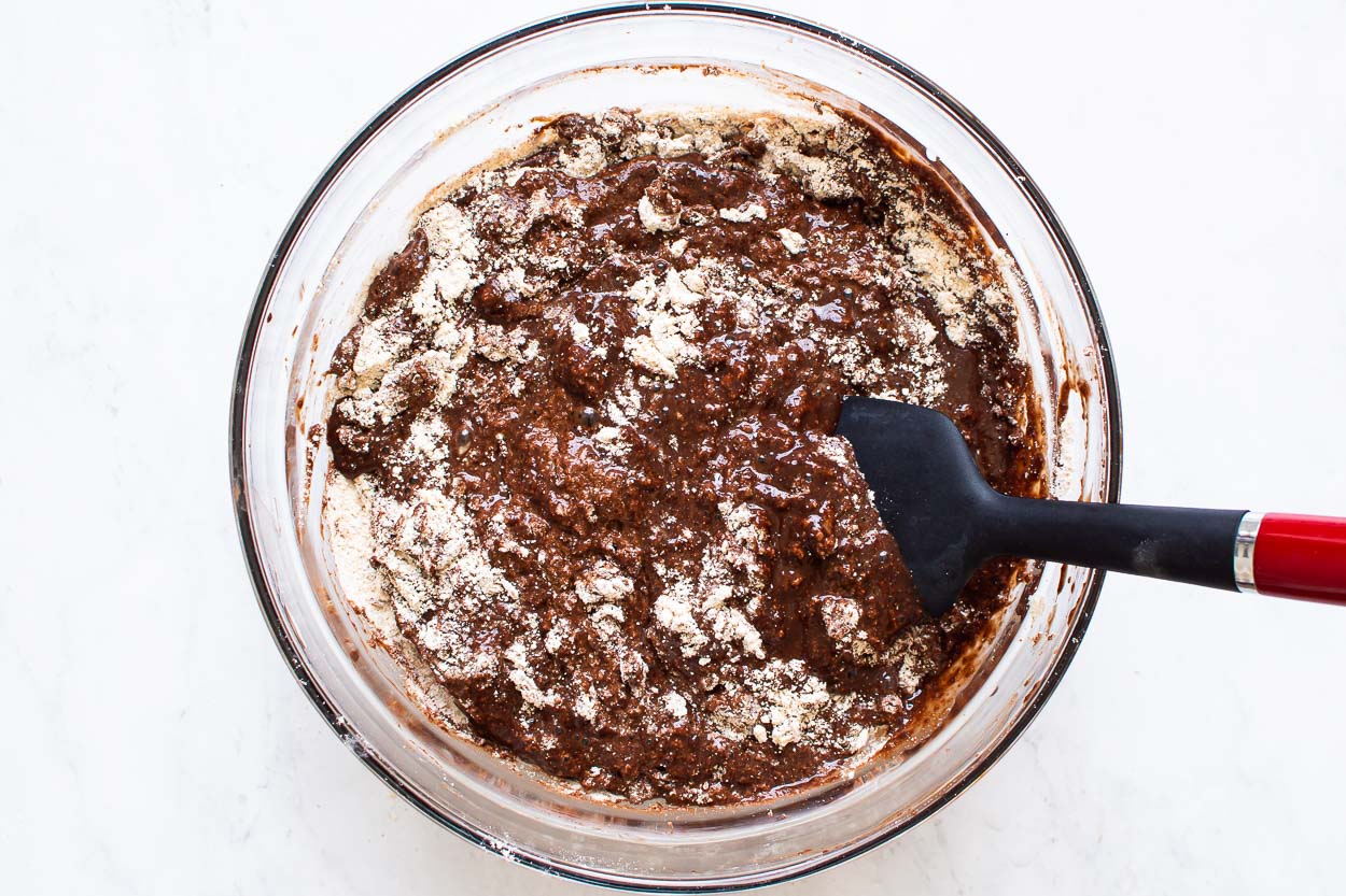 A spatula stirring flour into cacao powder mixture. 