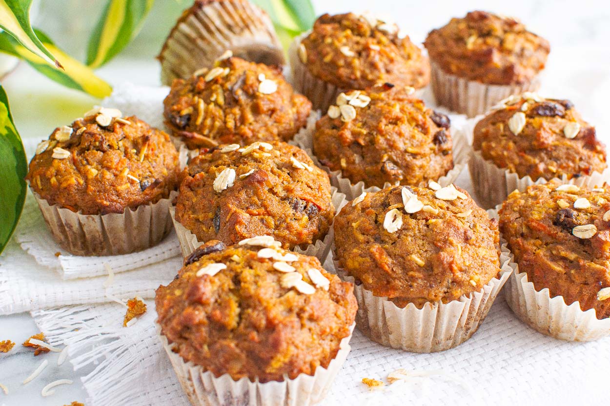 Healthy morning glory muffins studded with oats and on a white linen.